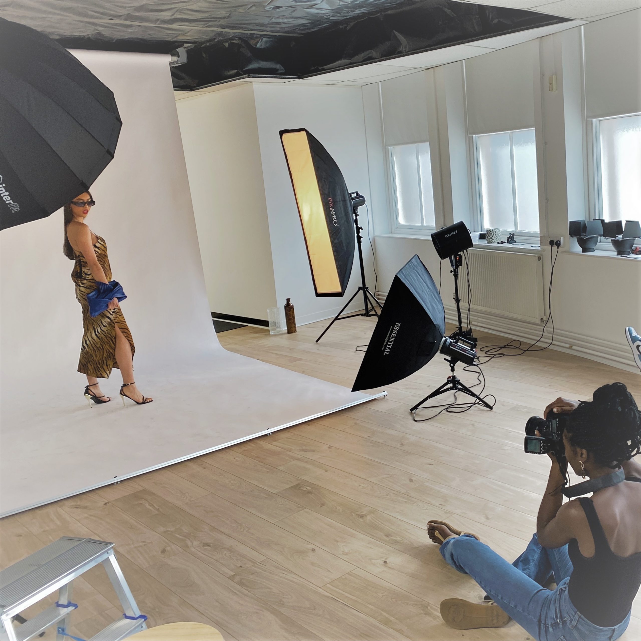 Large photography studio space showing photographer, model, photography backdrop and photography lighting