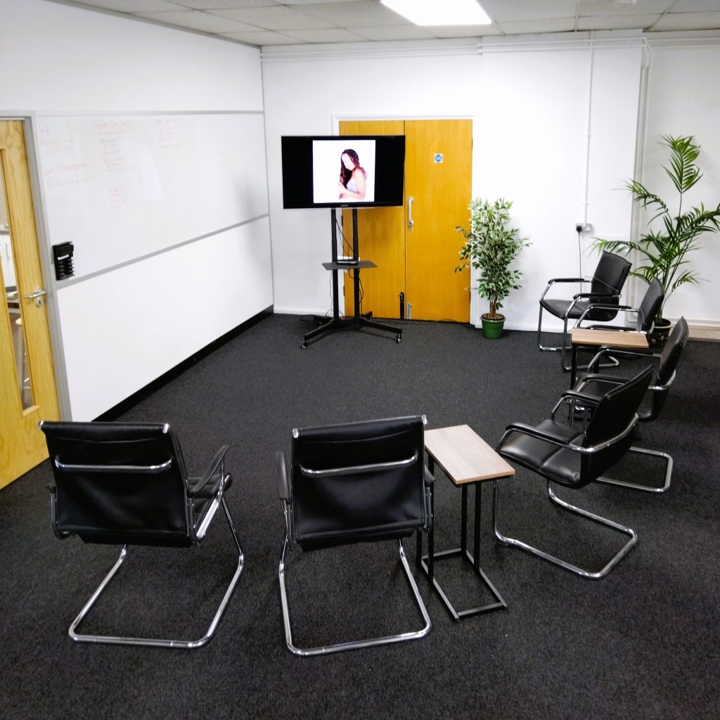 Classroom setting with a curve of chairs and TV screen