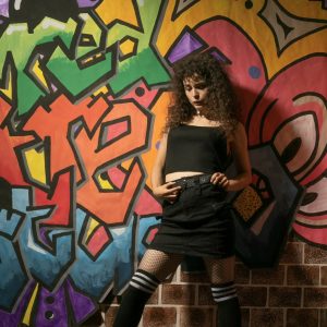 Model leaning against a graffiti wall